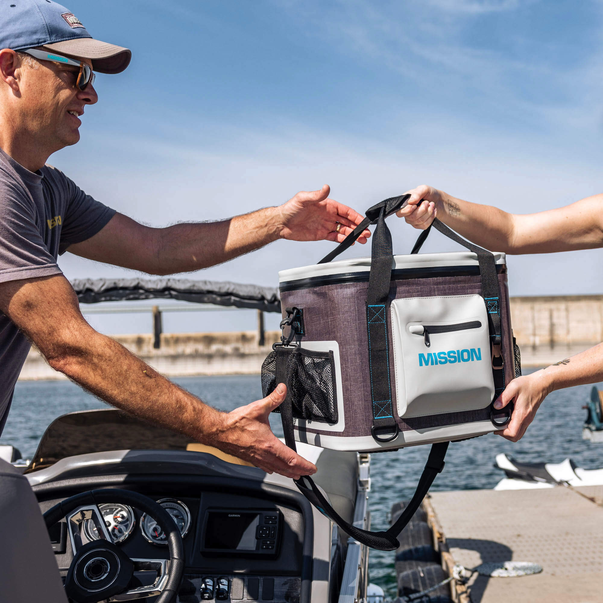 person handing soft pack cooler to another person