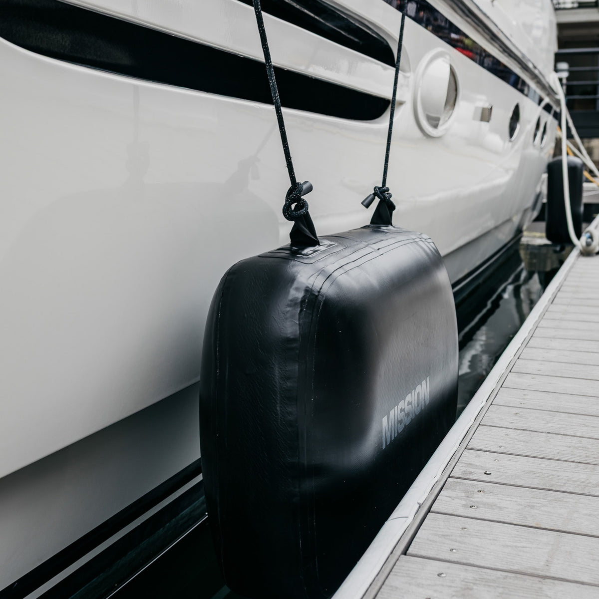 MISSION BRIGADE Fender in black hanging on boat against dock
