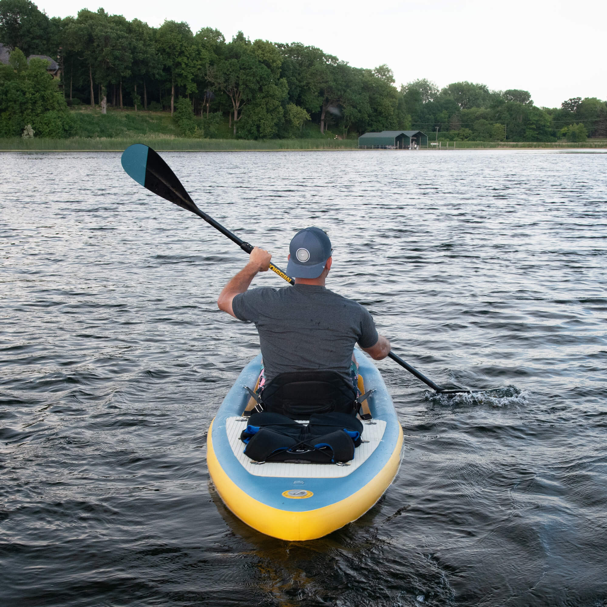 back view of person paddling in STILLWATER Inflatable Kayak + iSUP Crossover on lake