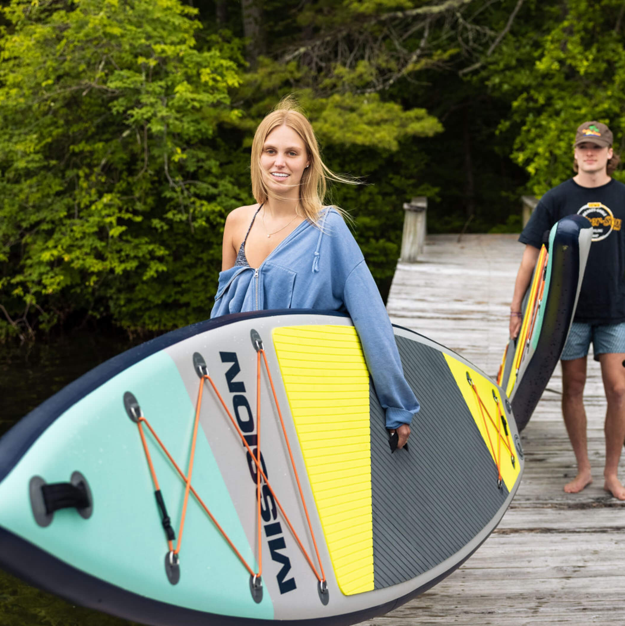 person carrying TRIDENT Inflatable Touring SUP