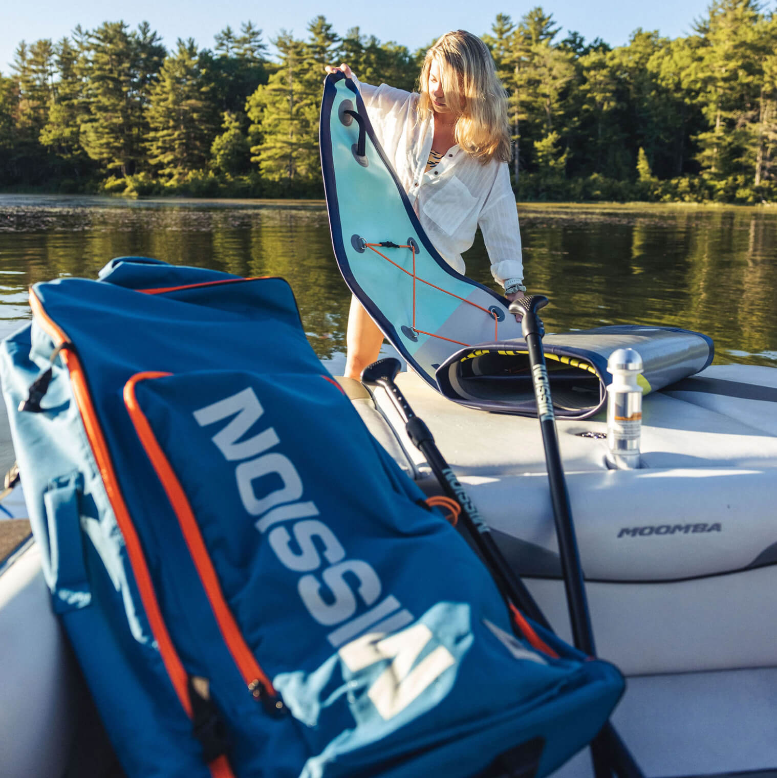 person pulling out TRIDENT Inflatable Touring SUP on boat