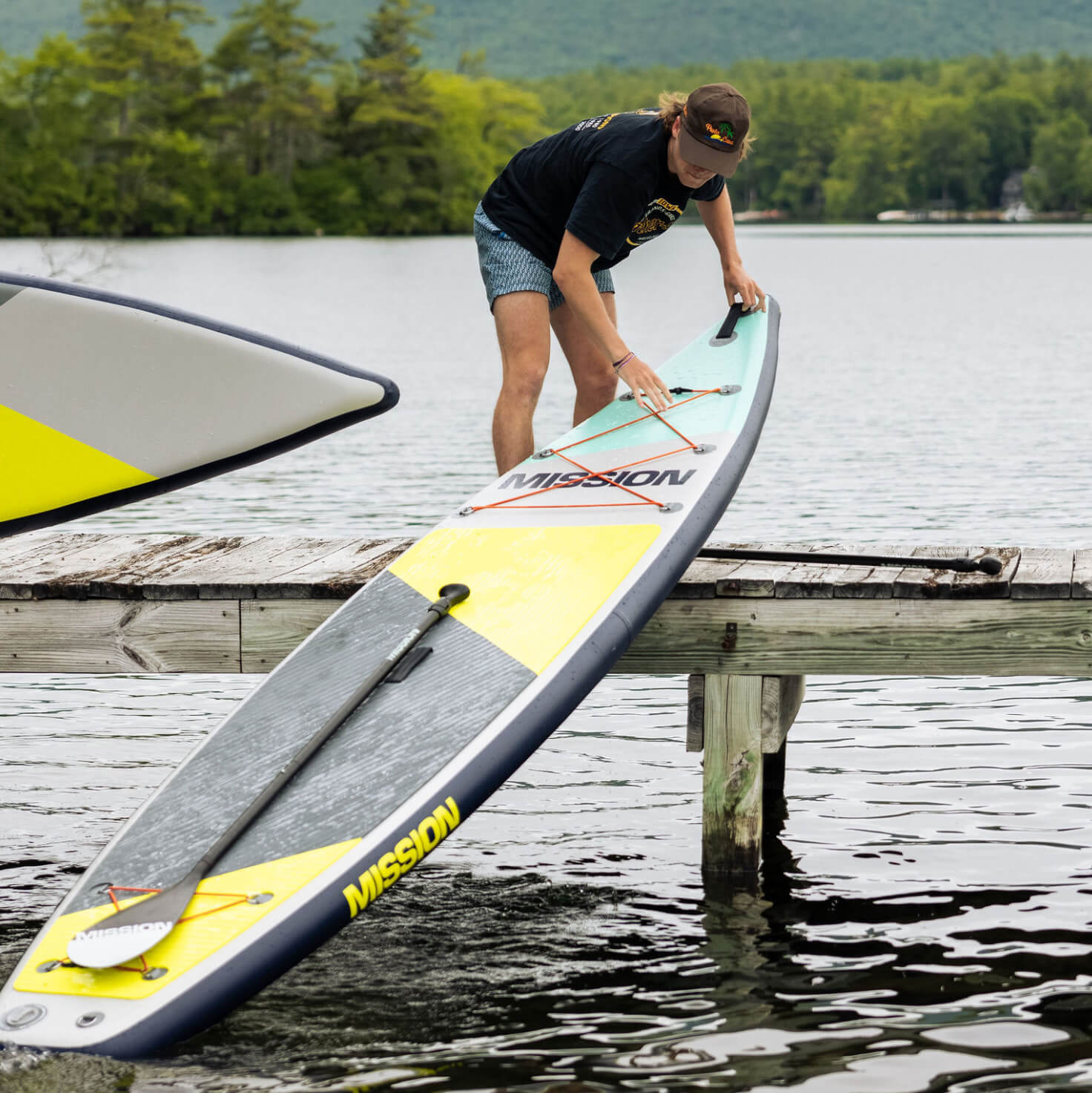 person pulling up TRIDENT Inflatable Touring SUP on to dock