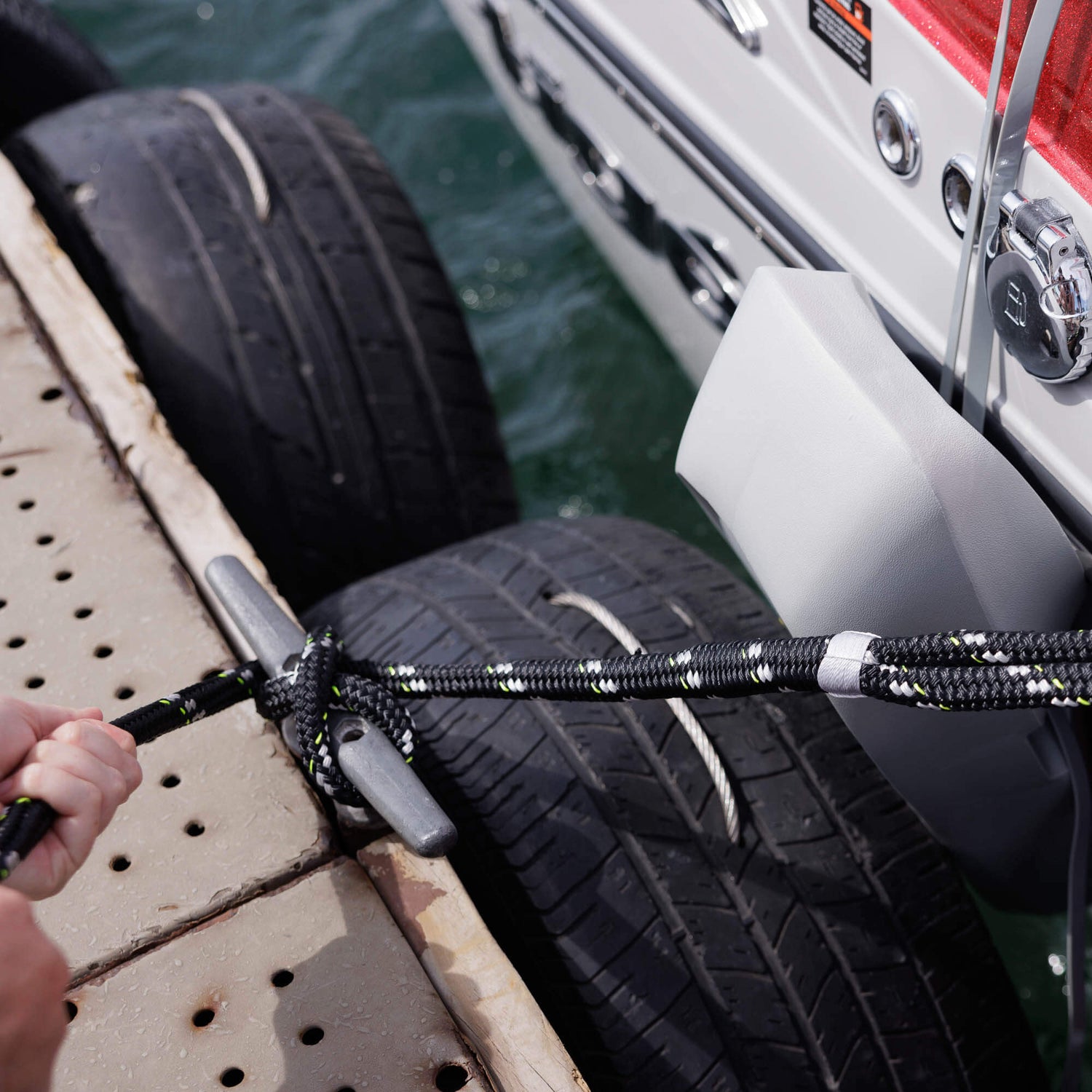 person tying up boat with dock lines